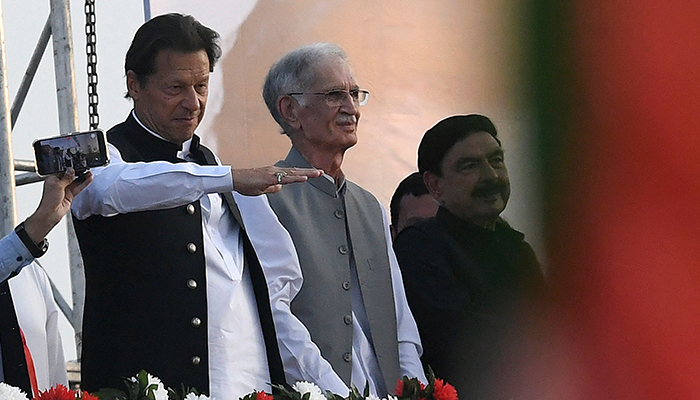 Minister Imran Khan (L) along with other lawmakers, gestures upon his arrival to address the supporters of the ruling Pakistan Tehreek-e-Insaf (PTI) party during a rally in Islamabad on March 27, 2022. — AFP