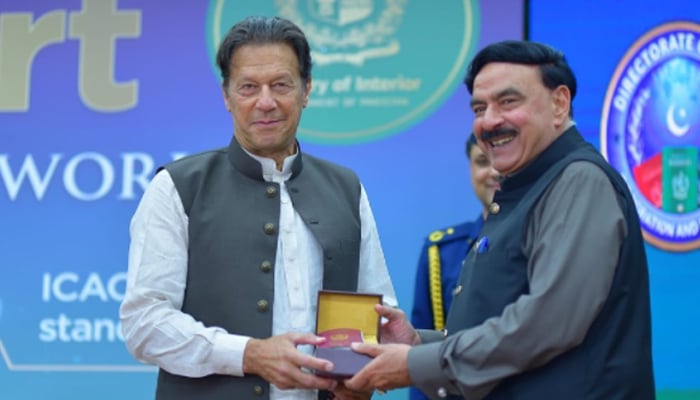 Prime Minister Imran Khan hands over a token of appreciation to Interior Minister Sheikh Rasheed during the launching ceremony of electronic passports in Islamabad on March 30- 2022. — Instagram