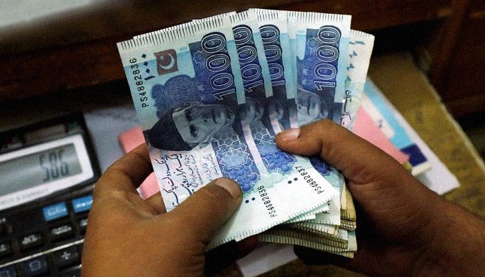 A trader counts Pakistani rupee notes at a currency exchange booth in Peshawar, Pakistan, December 3, 2018. — Reuters/Fayaz Aziz/Files