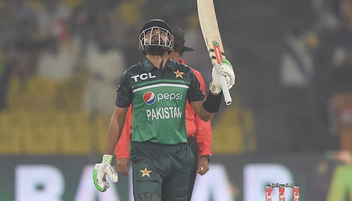 Kapten Pakistan Babar Azam merayakan setelah mencetak setengah abad (50 run) selama pertandingan kriket internasional satu hari pertama (ODI) antara Pakistan dan Australia di Stadion Kriket Gaddafi di Lahore pada 29 Maret 2022. — AFP