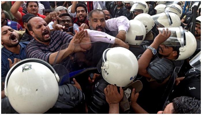 Workers of political parties scuffle with policemen during a protest in Lahore. Photo: AFP/ file