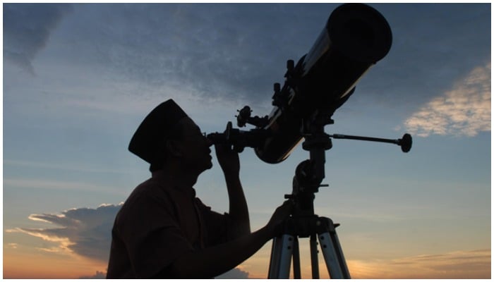 A person sighting the moon through a telescope. — AFP/File
