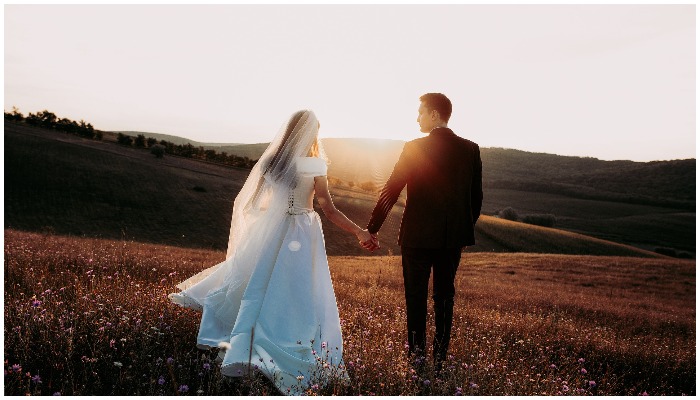 Representational image of a bride and groom holding hands. — Pixabay/OlcayErtem