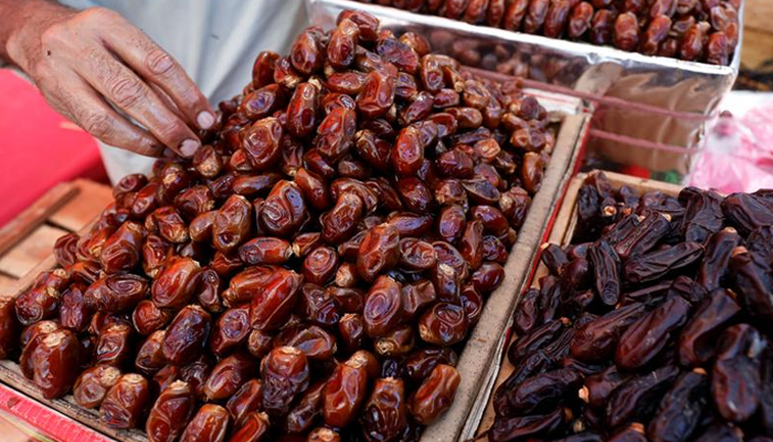 A vendor sets the dates while selling them from a stall, ahead of the Muslim holy month of Ramadan, amid spread of the coronavirus disease (COVID-19), in Karachi, Pakistan April 22, 2020. — Reuters