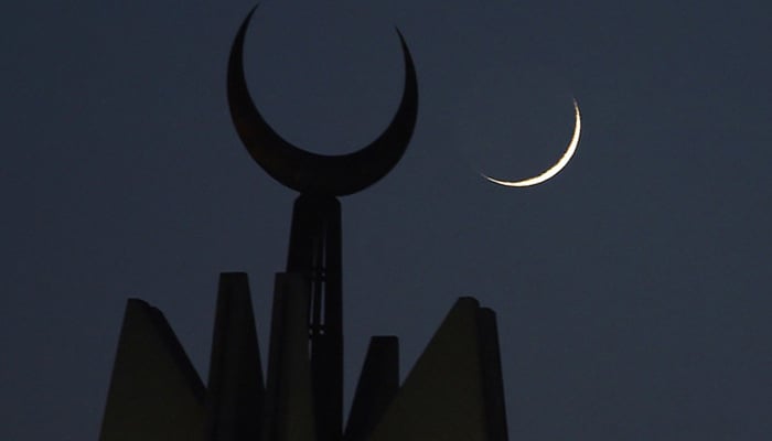 In this file photo, the first Ramadan moon rises over the giant Faisal Mosque in Islamabad on May 27, 2017. — AFP