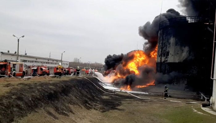 A still image taken from video footage shows members of the Russian Emergencies Ministry extinguishing a fire at a fuel depot in the city of Belgorod, Russia April 1, 2022. Russian Emergencies Ministry/Handout via REUTERS