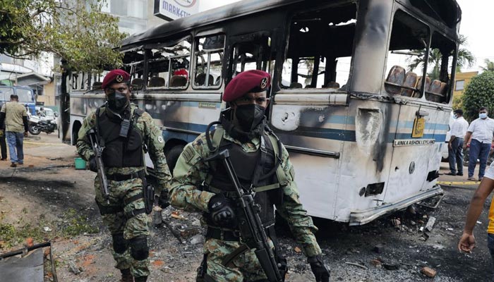 Sri Lankan army commandos walk past a damaged bus after it was set on fire by demonstrators at the top of the road to Sri Lankan President Gotabaya Rajapaksas residence during a protest against him  in Colombo, Sri Lanka April 1, 2022. — Reuters/File