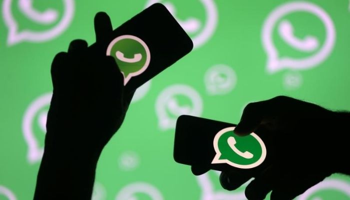 Men pose with smartphones in front of displayed Whatsapp logo in this illustration September 14, 2017. — Reuters/ File