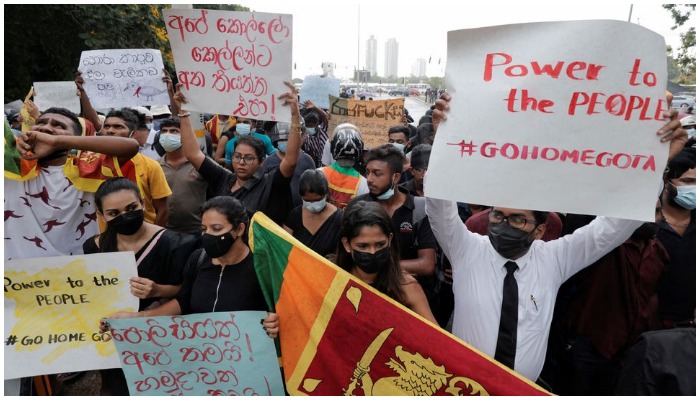 People hold placards as they demand Sri Lankas President Gotabaya Rajapaksa to resign after his government lost its majority in the parliament, amid the countrys economic crisis, during a protest near to a road leading to the parliament building in Colombo, Sri Lanka, April 5, 2022. — Reuters/File