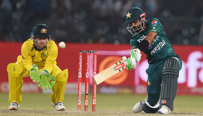 Pakistans captain Babar Azam (R) plays a shot as Australia´s wicketkeeper Josh Inglis (L) looks during the Twenty20 international cricket match between Pakistan and Australia at the Gaddafi Cricket Stadium in Lahore on April 5, 2022. — AFP