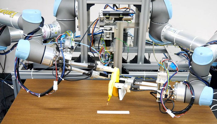 A dual-armed robot picks up a banana and peels it without squashing the fruit inside during a demonstration in this handout image taken December 2, 2021 and released by ISI (Kuniyoshi) Lab., School of Info. Sci & Tech., The University of Tokyo, Japan. Handout via REUTERS