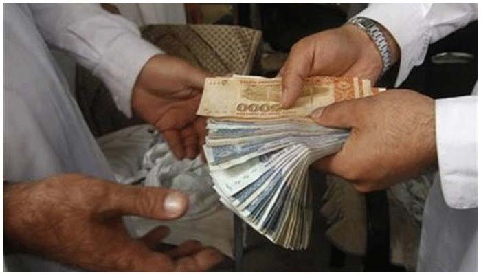 A currency dealer exchanging Rs1,000 and Rs5,000 notes. — Reuters/File