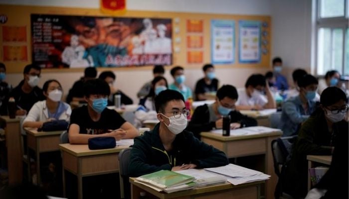 Siswa yang mengenakan masker terlihat di dalam ruang kelas selama tur media yang diselenggarakan pemerintah di sebuah sekolah menengah ketika lebih banyak siswa kembali ke kampus setelah wabah penyakit virus corona (COVID-19), di Shanghai, Cina, 7 Mei 2020. — Reuters
