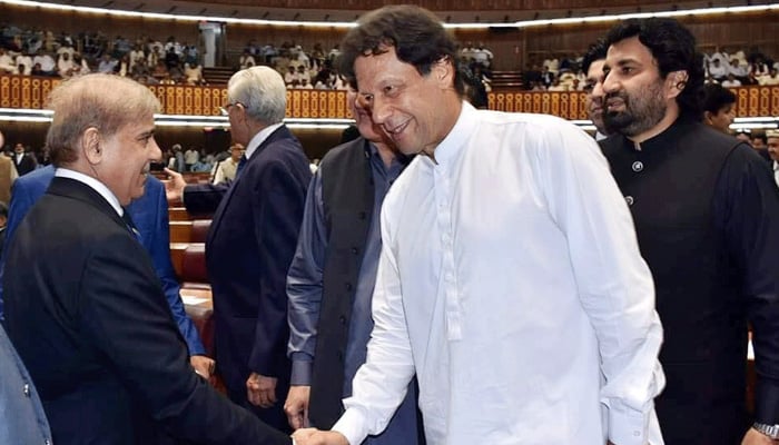 PML-N President and Leader of the Opposition in the National Assembly Shahbaz Sharif and Prime Minister Imran Khan shake hands in Parliament in this undated photo. — Twitter/File