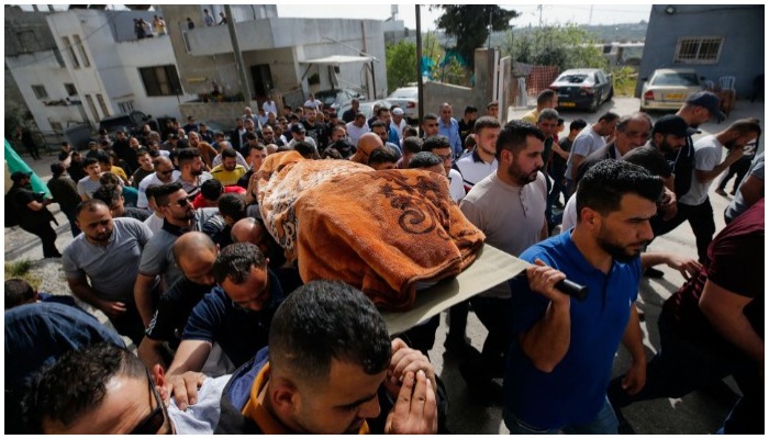 People carry the body of Palestinian woman Ghada Sabatin, who medics said was killed by Israeli forces, during her funeral in Husan in the Israeli-occupied West Bank on April 10, 2022. &mdash; Reuters/Mussa Qawasma