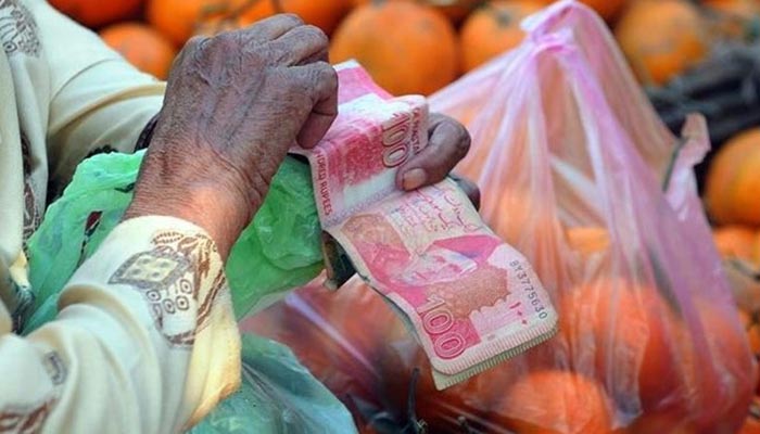 A picture shows a person holding hundred rupee notes. — AFP/File