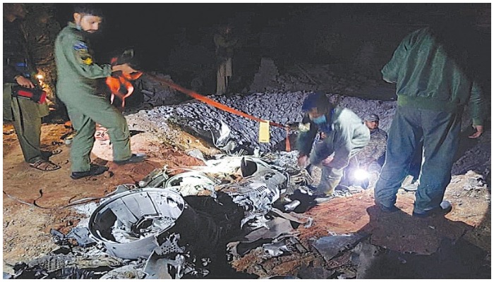 This file photo shows workers trying to salvage parts of what the Pakistan military says are the remains of a missile fired from India, near Mian Channu. —Reuters