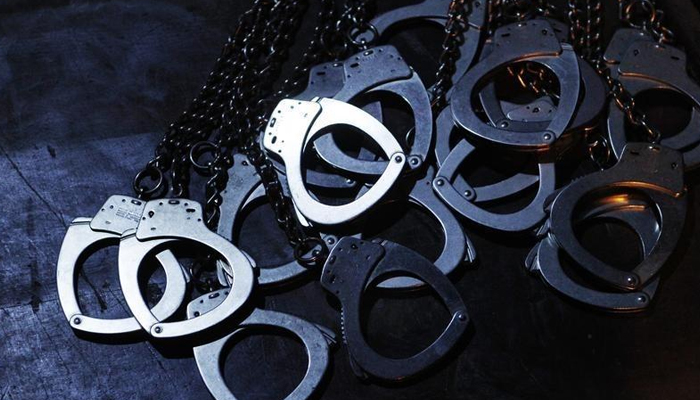 The handcuffs of inmates are seen during a play at a public theatre in Lima, June 20, 2012. — Reuters