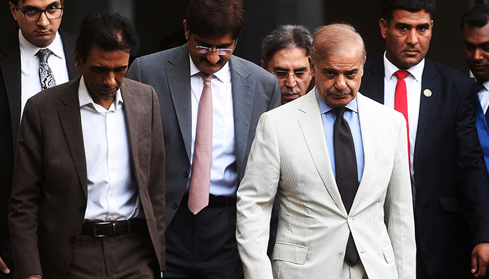 Prime Minister Shehbaz Sharif (2R) and leader of the Muttahida Qaumi Movement-Pakistan (MQM-P) and collation partners of the newly formed government Khalid Maqbool Siddiqui (L) leave after a meeting in Karachi on April 13, 2022. — AFP