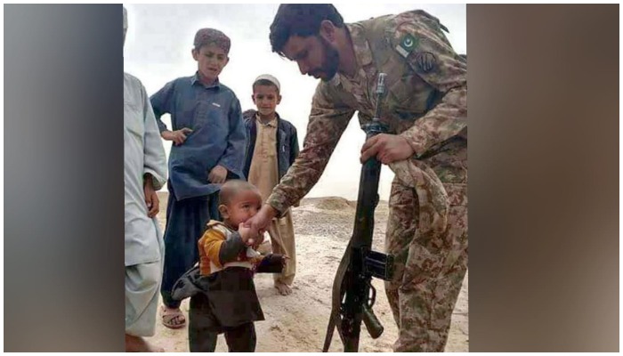 Young Baloch child kissing the hands of a Pakistan Army soldier. — APP