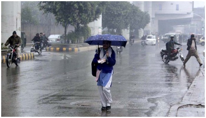A girl student walks on the roads under the cover of umbrella during rain that experienced in Lahore on January 22, 2022. — APP/File