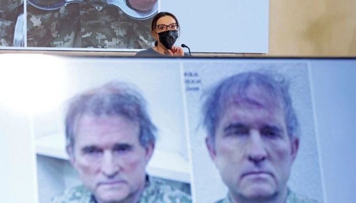 Oksana Marchenko, wife of pro-Russian Ukrainian politician Viktor Medvedchuk who was detained in Ukraine, attends a news conference, while pictures of her husband are displayed on screens, in Moscow, Russia April 15, 2022. Reuters