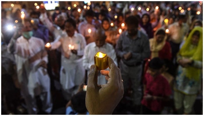 Christian devotees hold candles during an Easter vigil procession at Central Brooks Memorial Church, in Karachi. — AFP/ file
