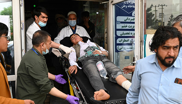 Medical staff move a wounded youth on a stretcher outside a hospital after three blasts rocked a boys´ school in a Hazara neighbourhood in Kabul on April 19, 2022. — AFP