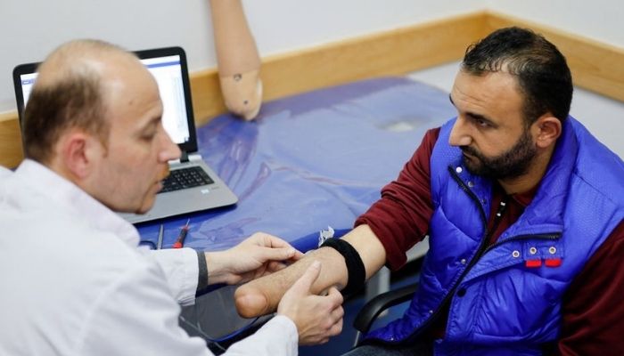 Ahmed Abu Hamda, 36, who lost his right hand in 2007 and was fitted with a myoelectric limb, has his arm checked at the Sheikh Hamad Bin Khalifa Al Thani Rehabilitation and Prosthetics Hospital in the northern Gaza Strip April 13, 2022. Picture taken April 13, 2022. Reuters
