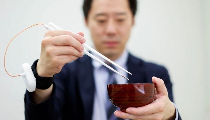 An employee of Kirin Holdings demonstrates chopsticks that can enhance food taste using an electrical stimulation waveform that was jointly developed by the company and Meiji Universitys School of Science and Technology Professor Homei Miyashita, in Tokyo, Japan April 15, 2022. — Reuters