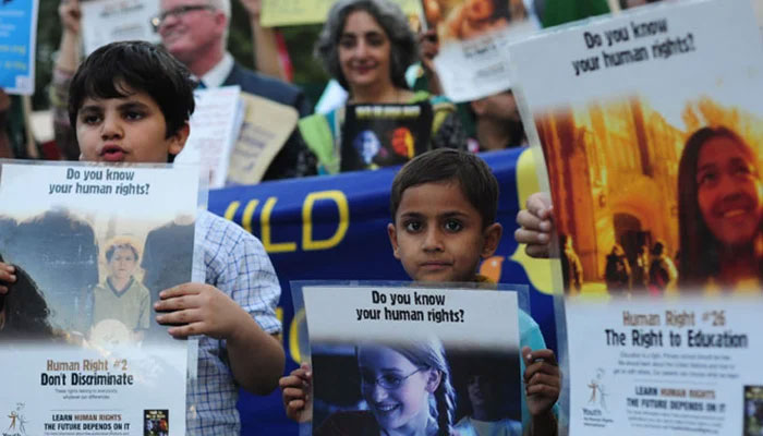 Pakistani children and activists carry placards during a peace walk to mark Human Rights Day in Karachi. — AFP/File