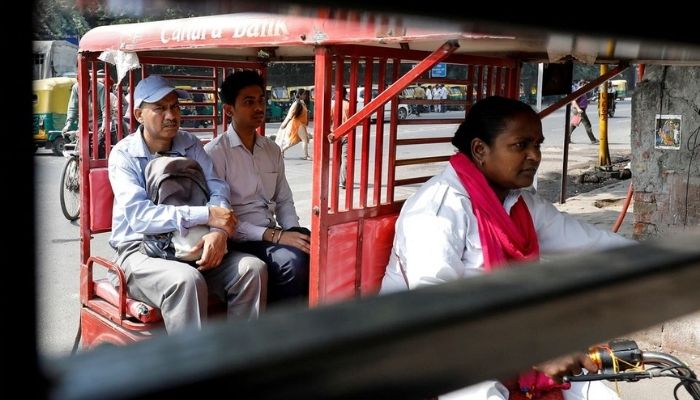 Binota Gayen, 45, rides an electric rickshaw carrying passengers in New Delhi, India, on October 5, 2018.— Reuters