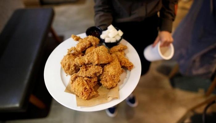 An employee serves fried chicken at a pub in Seoul, South Korea, October 11, 2016..—Reuters
