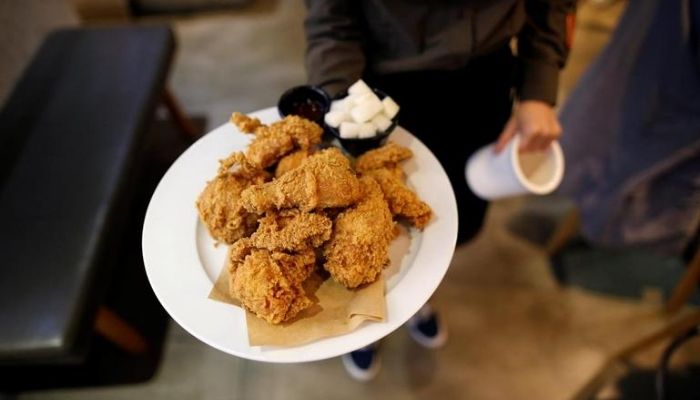 An employee serves fried chicken at a pub in Seoul, South Korea, October 11, 2016..—Reuters