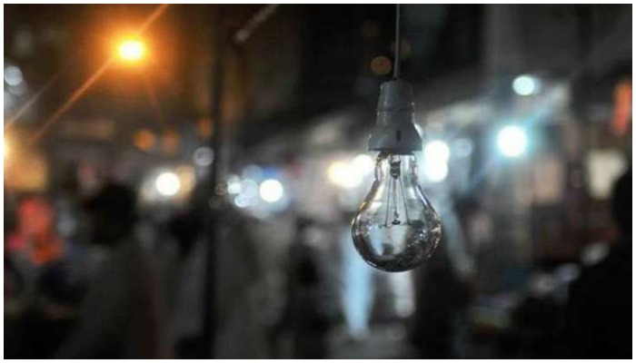 A switched of bulb is seen hanging at a market place in Karachi. — AFP/ file