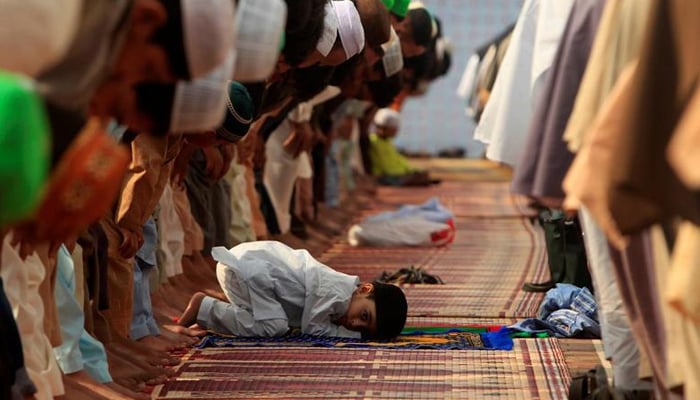A boy attends Eid al-Fitr prayers with others at Jamia Masjid in Rawalpindi, Pakistan, on July 6, 2016. — Reuters