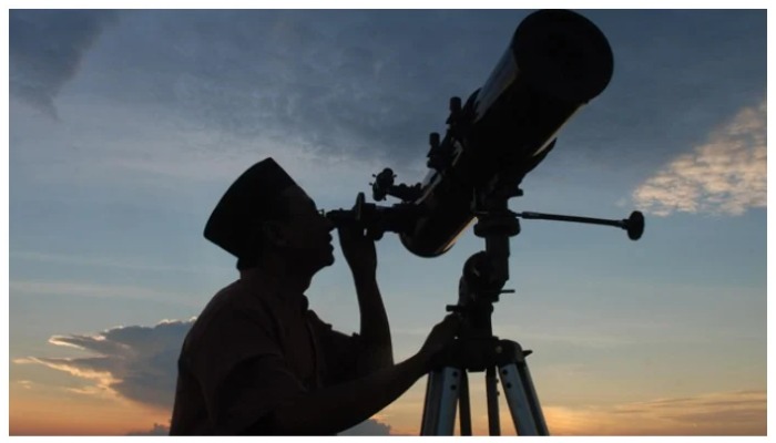 A person sighting the moon through a telescope. — AFP/ file