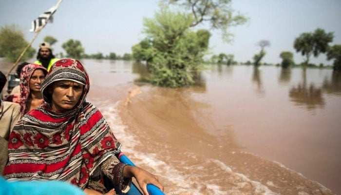 A representational image of a flood victim sitting on a boat while being evacuated from her flooded house following heavy rain in Jhang, Punjab. — Reuters/File
