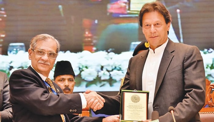 Ex-chief justice Mian Saqib Nisar presenting an appreciation shield to ex-prime minister Imran Khan in Islamabad in December 2018. —APP/File