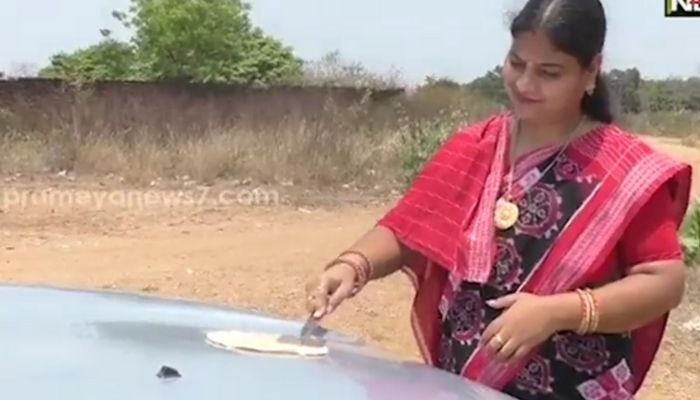 Woman cooks roti on bonnet of car. Screengrab via twitter/nilamadhapanda