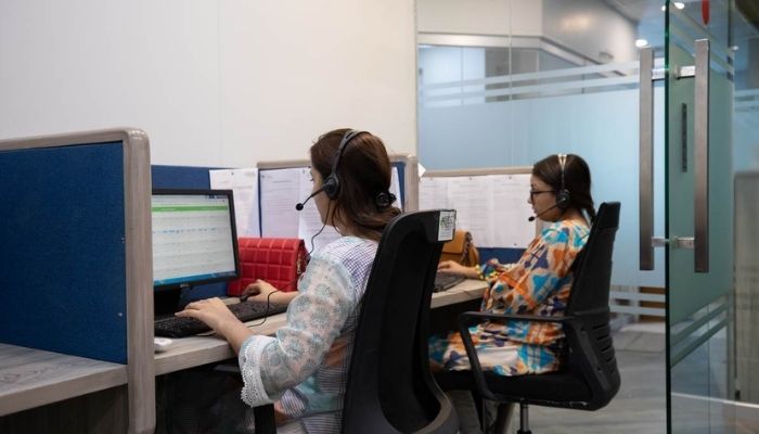 ہیلتھ ٹیک کمپنی صحت کہانی کے ملازمین 14 اپریل 2022 کو کراچی، پاکستان میں مرکزی دفتر میں کال کا جواب دے رہے ہیں۔— تھامسن رائٹرز فاؤنڈیشن/خوالہ جمیل۔