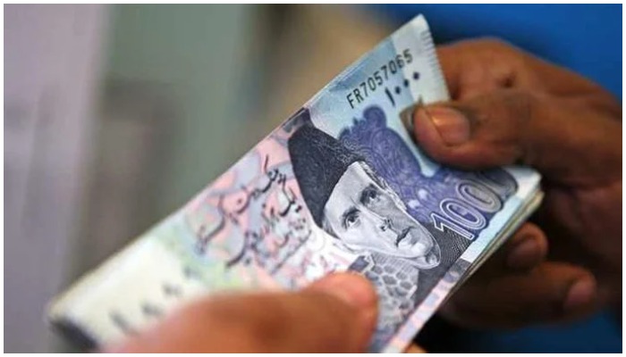 A man holds a bundle of Rs1000 notes. — AFP/ file