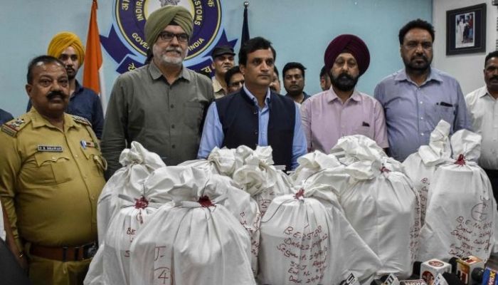 Indian customs officials stand next to boxes of suspected drugs weighing 102 kilogrammes during a news conference held in Amritsar, India, on April 24, 2022.—AFP