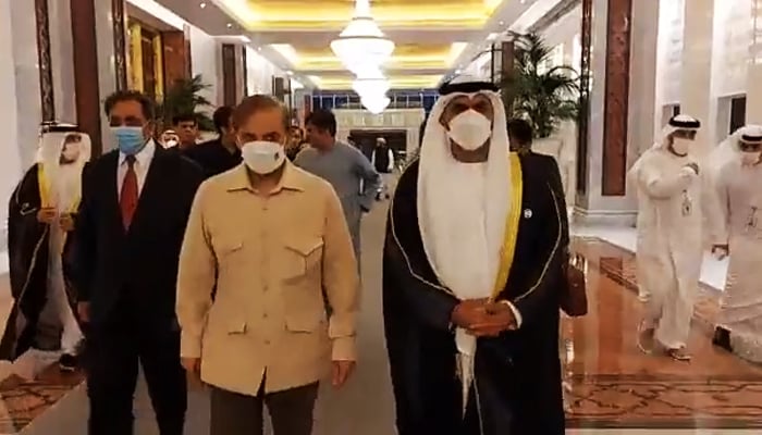 Prime Minister Shehbaz Sharif (left) walks with UAE Minister for Justice Abdullah bin Sultan Al-Nuaimi after arriving in the United Arab Emirates, on April 30, 2022. — Screengrab from video shared by Prime Ministers Office