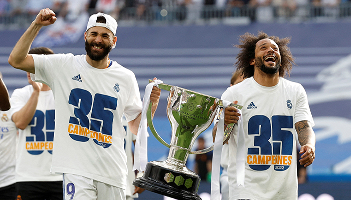 Soccer Football - LaLiga - Real Madrid v Espanyol - Santiago Bernabeu, Madrid, Spain - April 30, 2022, Real Madrids Marcelo and Karim Benzema hold the trophy and celebrate with team members after winning LaLiga. — Reuters