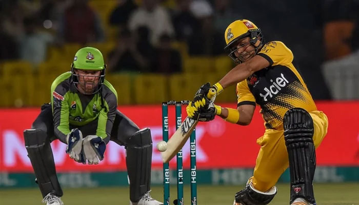 Peshawar Zalmis Kamran Akmal plays a shot as Ben Dunk of the Qalandars looks on. Photo: AFP/file