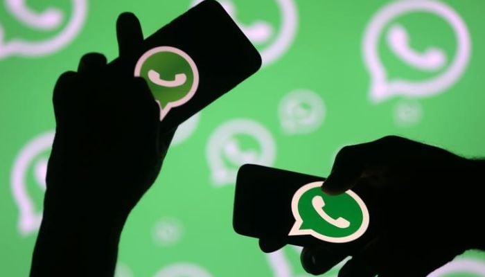 Men pose with smartphones in front of displayed Whatsapp logo in this illustration September 14, 2017. .— Reuters