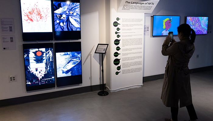 A visitor takes pictures of signage during The Climate Conversation’ exhibition at Seattle NFT Museum, the first permanent blockchain-based digital art museum in the world, in Seattle, Washington, US, on April 16, 2022. — Reuters