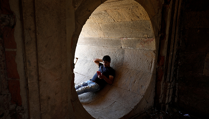 A man rests in a dry water tunnel of the Sarkhej Roza lake during hot weather in Ahmedabad, India, on April 28, 2022. — Reuters