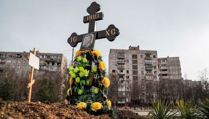 Graves of civilians killed during Ukraine-Russia conflict are seen next to apartment buildings in the southern port city of Mariupol, Ukraine, April 10, 2022. Photo: Reuters